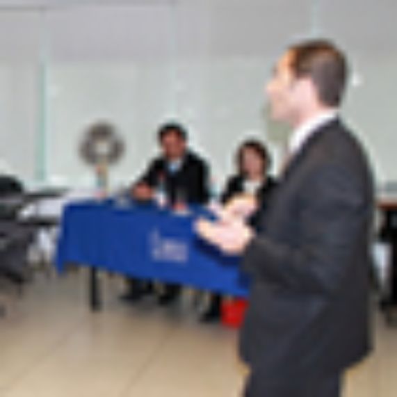 El profesor Varsi expone ante estudiantes del programa, acompañado por la vicedecana, Maricruz Gómez de la Torre, y el profesor Cristián Lepin.