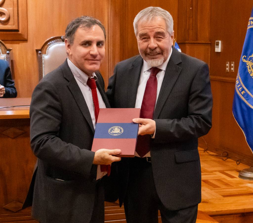 El Decano (s) Francisco Soto recibió una copia de la memoria de título de Arturo Prat de manos del ministro Gabriel Ascencio.